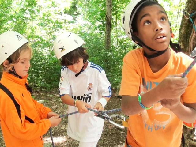 Enfants pratiquant la descente en rappel en escalade