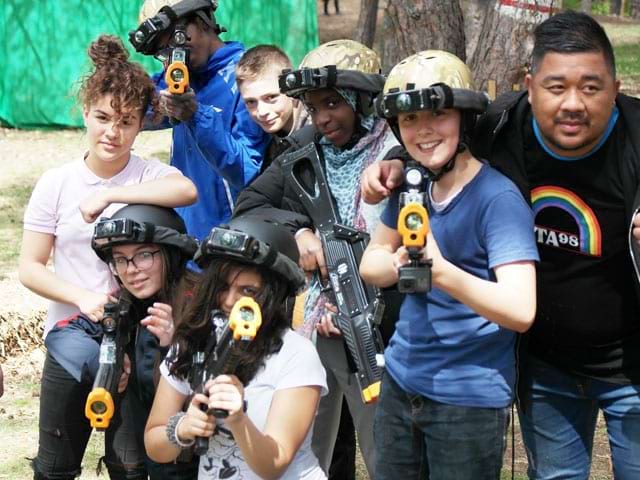 groupe d'ados faisant du laser game en colonie de vacances