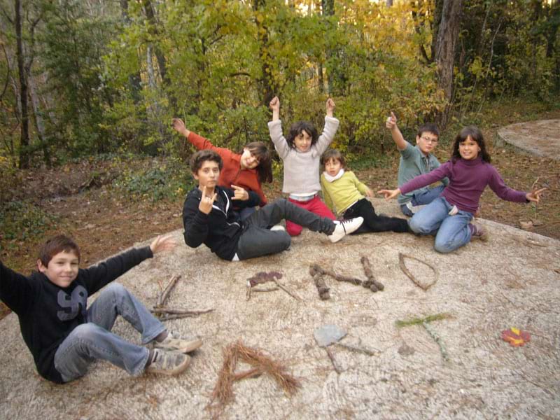 Groupe d'enfants assis par terre en campagne en colonie de vacances d'hiver multiactivités