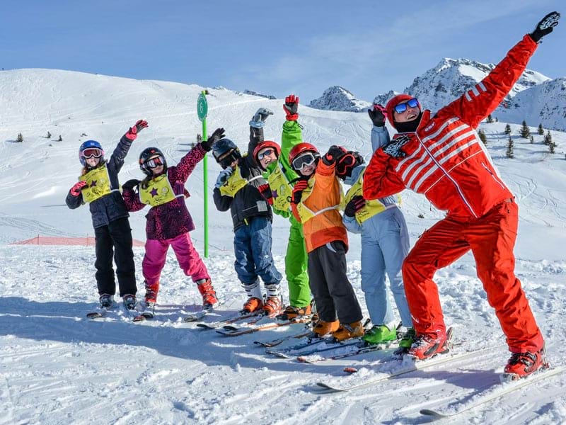 Groupe d'enfants sur les pistes de ski en colo