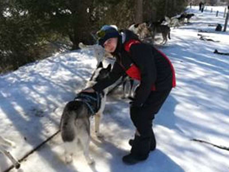 Enfant avec un chien de traineaux en colonie de vacances