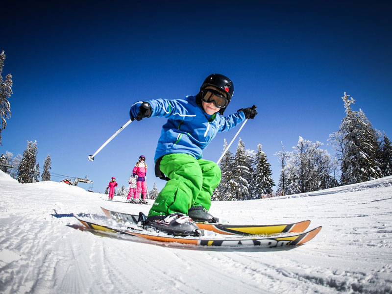 Enfant pratiquant le ski alpin en colonie de vacances