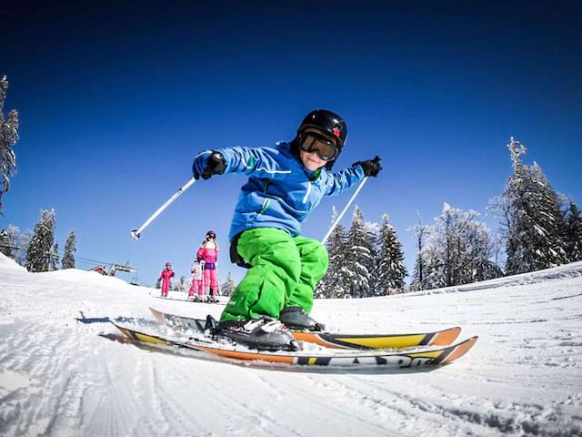 Enfant pratiquant le ski alpin en colonie de vacances