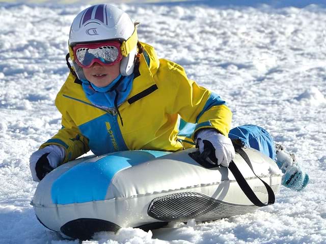 Enfant pratiquant la luge airboard en colonie de vacances