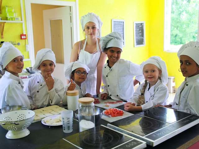 Enfants apprenant à cuisiner en colonie de vacances