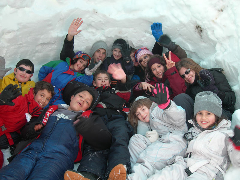 groupe d'enfants dans un igloo construit en colonie de vacances