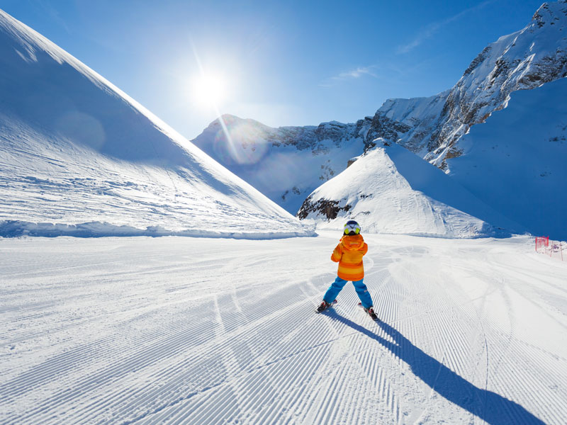 enfant dévalant les pistes de ski en colo