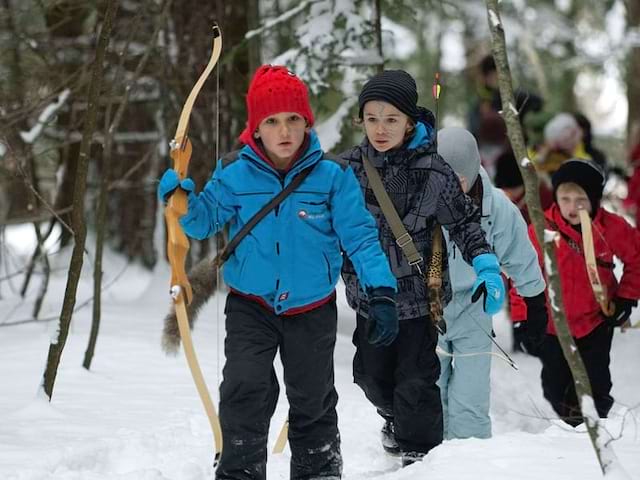 Enfants pratiquant le tir à l'arc des neiges en colonie de vacances