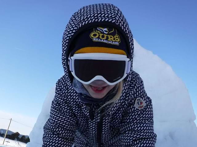 Enfant apprenant à construire un igloo en colonie de vacances