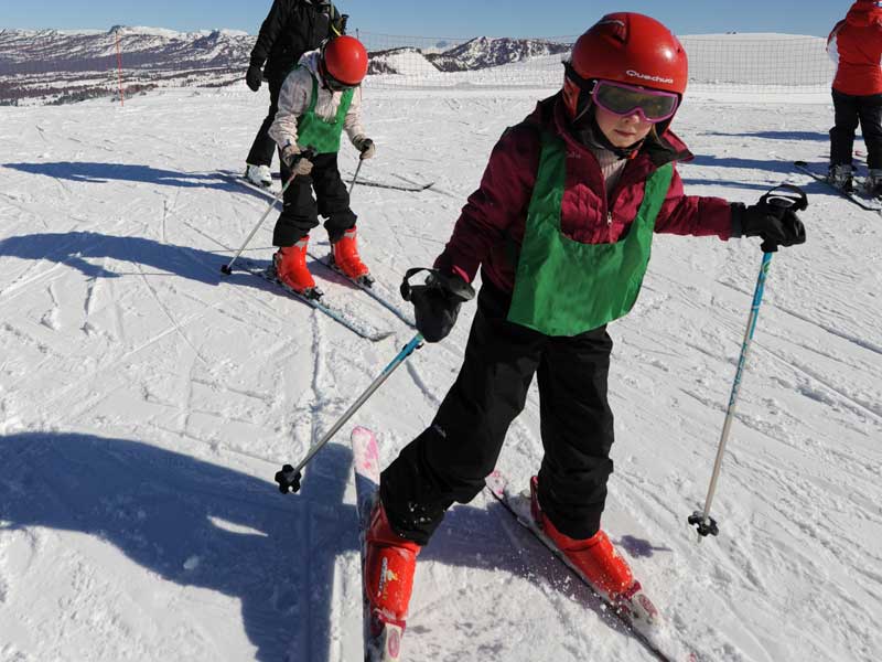 Enfant pratiquant le ski en colonie de vacances d'hiver