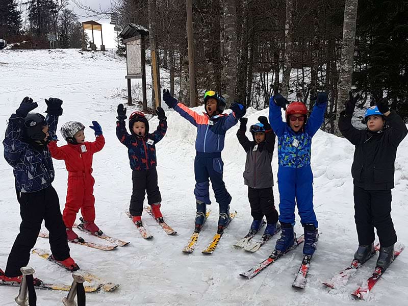 Groupe d'enfants dans la neige en colonie de vacances de février