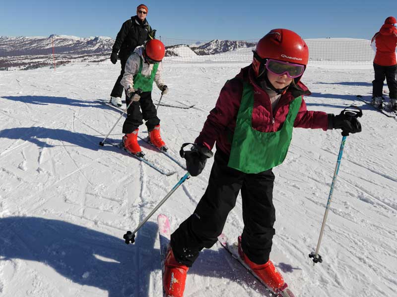 Enfant débutant apprenant à skier en colonie de vacances à la neige