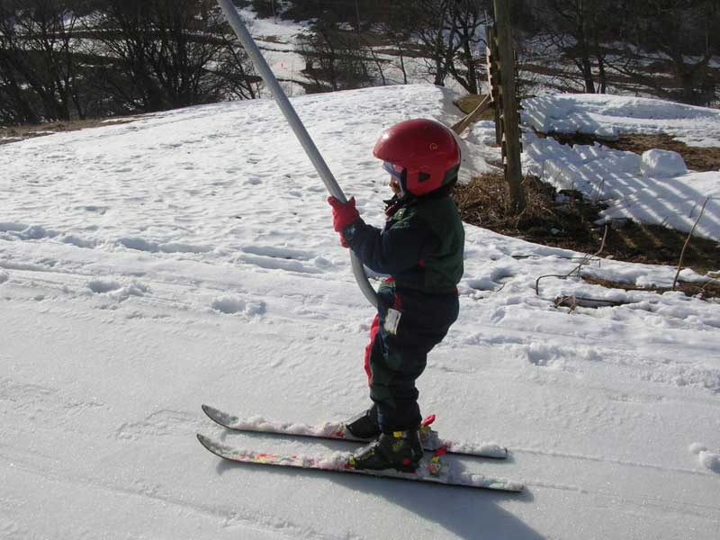 Enfant sur le tire fesse en colonie de vacances au ski