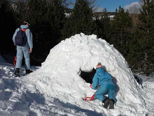 Enfants construisant un igloo en colonie cet hiver