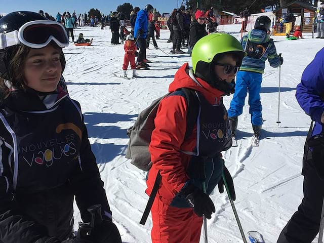 Enfants apprenant à skier en colonie de vacances cet hiver