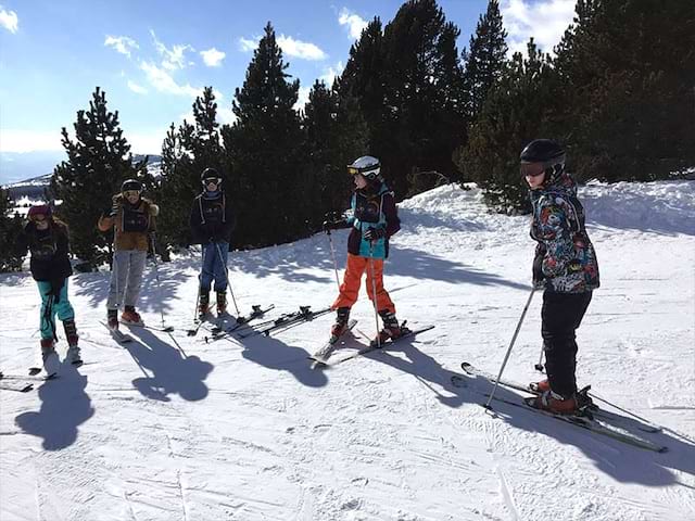 Groupe d'enfants sur les pistes de ski cet hiver en colonie de vacances