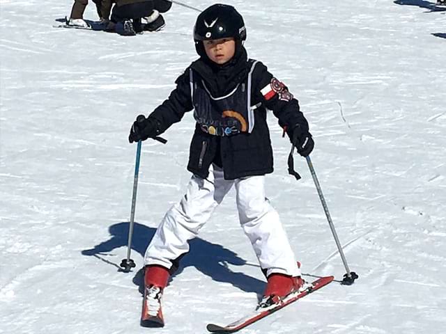 Jeune enfant de 7 ans apprenant à skier en colo cet hiver