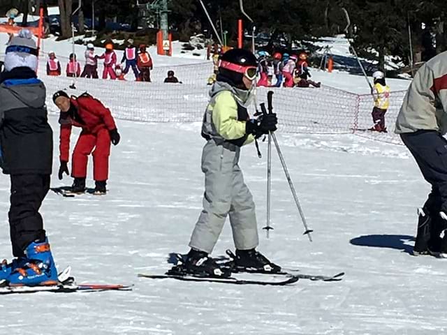 Fillette apprenant à skier en colonie de vacances d'hiver