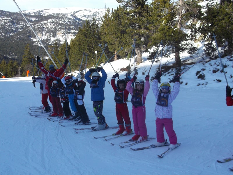 Groupe d'enfants alignés sur les pistes de ski en colonie de vacances