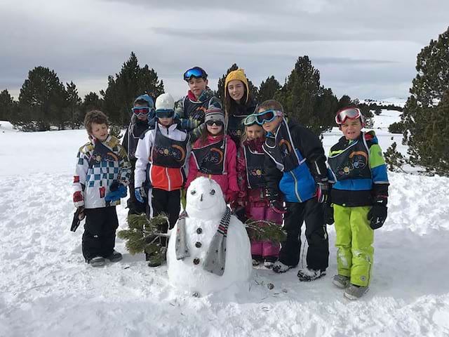 Groupe d'enfants de 8 ans faisant des bonhommes de neige en colo