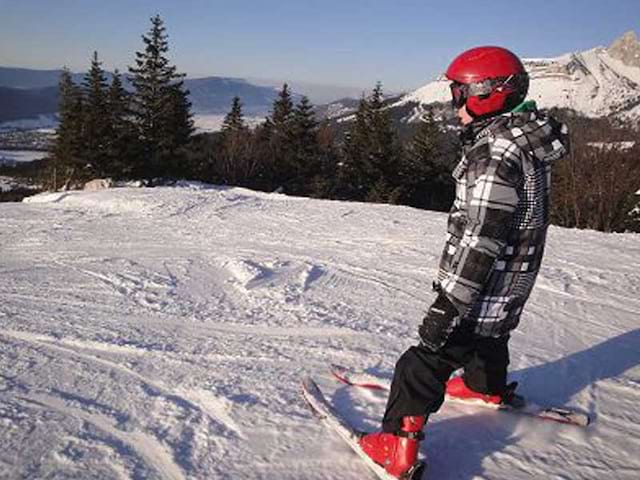 Skieurs débutants en colonie de vacances qui apprennent le ski avec des moniteurs ESF