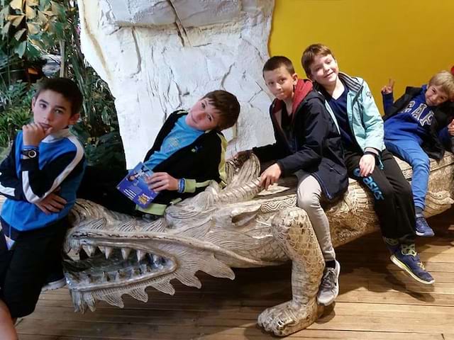 Enfants sur un crocodile factice en colonie de vacances cet hiver