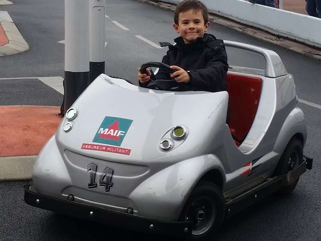 Enfant dans une petite voiture en colonie de vacances d'hiver