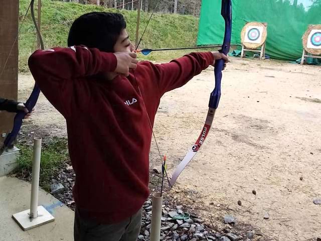 Enfant faisant du tir à l'arc en colo cet hiver