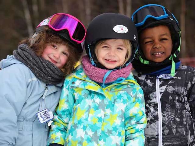 Fillettes apprenant à skier en colonie de vacances à la montagne