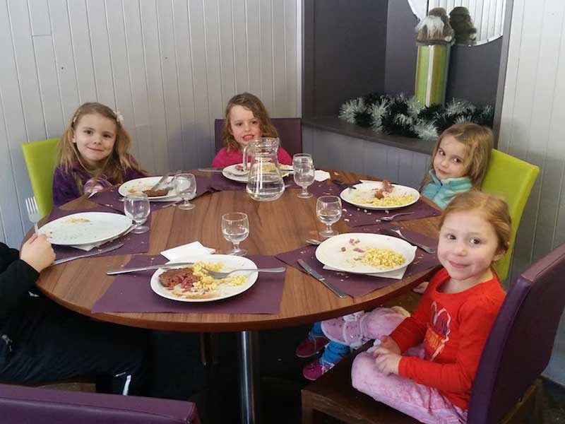 Groupe d'enfants à table en colonie de vacances à la montagne