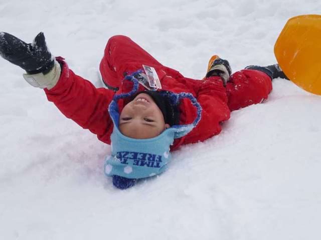 Enfant s'amusant dans la neige en colonie de vacances