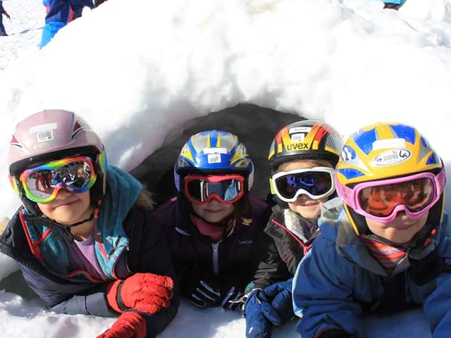 Groupe d'enfants dans un igloo en colonie de vacances d'hiver