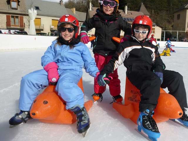 Trois enfants s'amusant sur la patinoire cet hiver