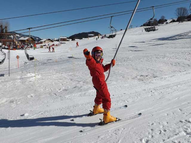 Enfant sur un tire fesse sur les pistes de ski de colonie de vacances cet hiver