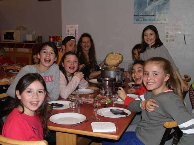 enfants à table en colo cet hiver à la neige