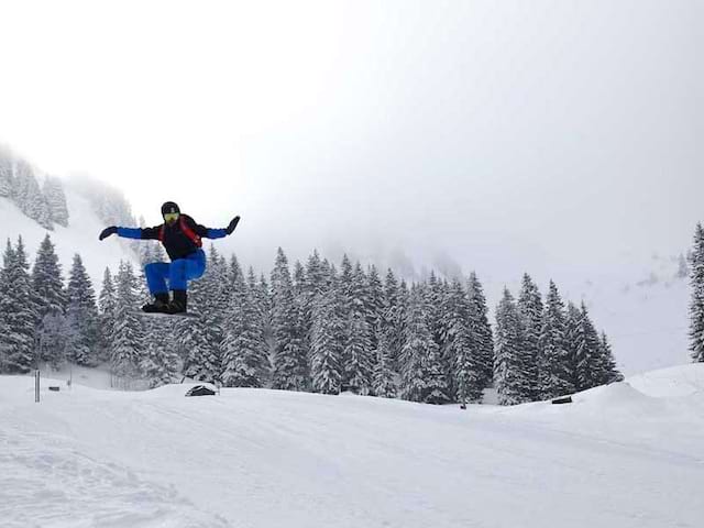 Ados pratiquant le saut en snowboard en colonie de vacances