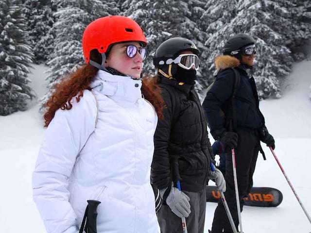 Ados sur les pistes de snowboard et ski en colonie de vacances à la montagne