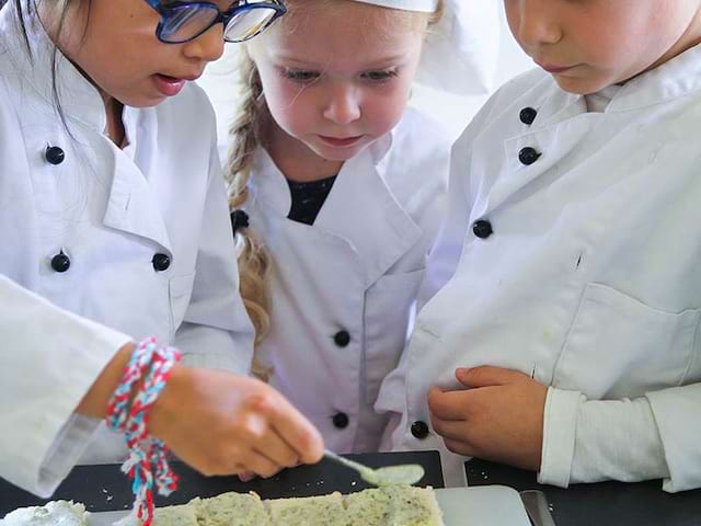 Enfants en train de cuisiner en colonie de vacances d'hiver