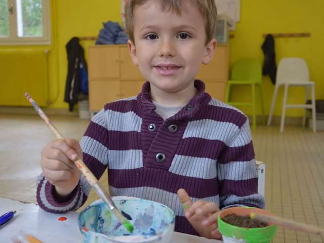 Enfant en train de faire un gateau en colo cet hiver