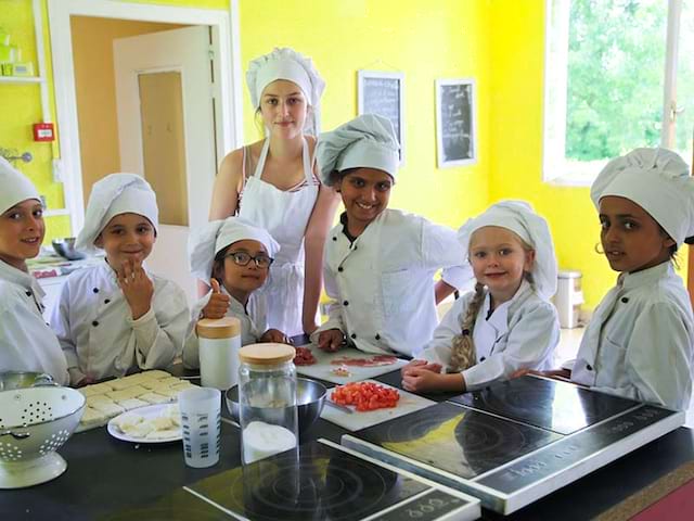 Groupe d'enfants en train de cuisiner en colo