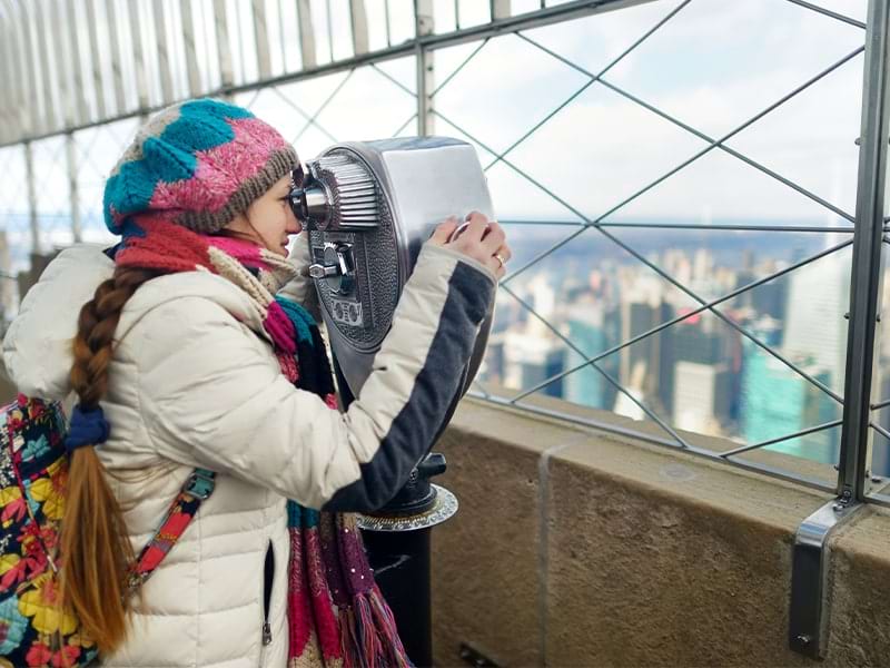 Jeune fille qui observe la ville de New York dans une jumelle lors d'une colonie de vacances à New York