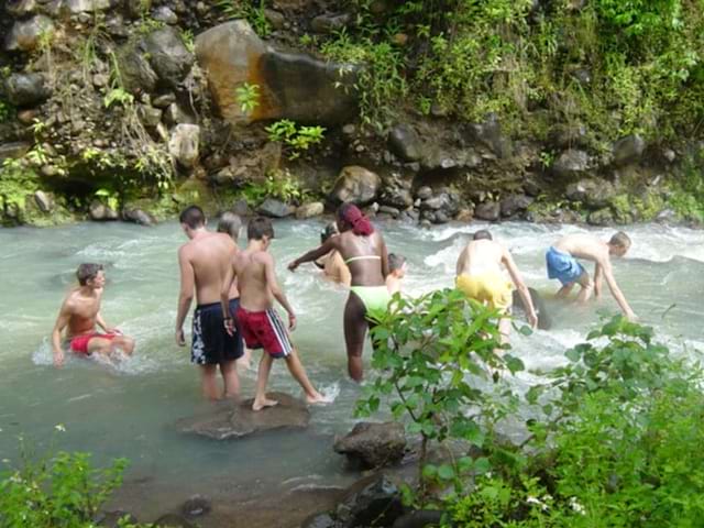 Baignade des enfants et ados dans une rivière lors d'une colo de vacances en Guadeloupe durant l'hiver