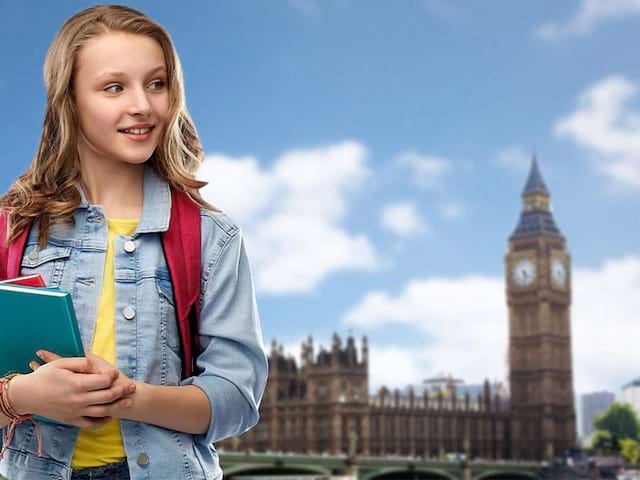 Enfant avec des cahiers devant Big Ben lors d'une colonie de vacances à Londres