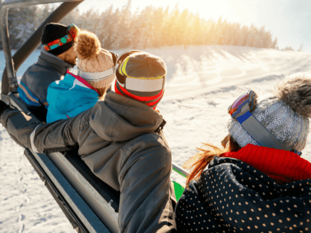 Groupe de jeunes en colo qui prend le télésiège cet hiver