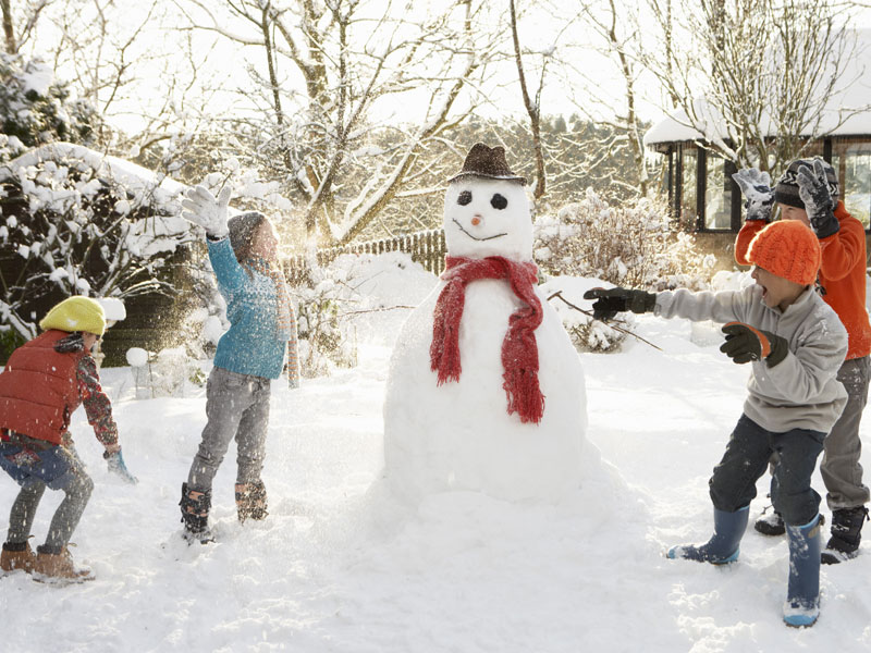 Jeux dans la neige bonhomme de neige en colo de vacances cet hiver