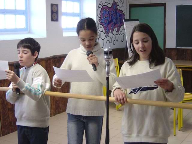 trois enfants faisant du chant en colonie de vacances