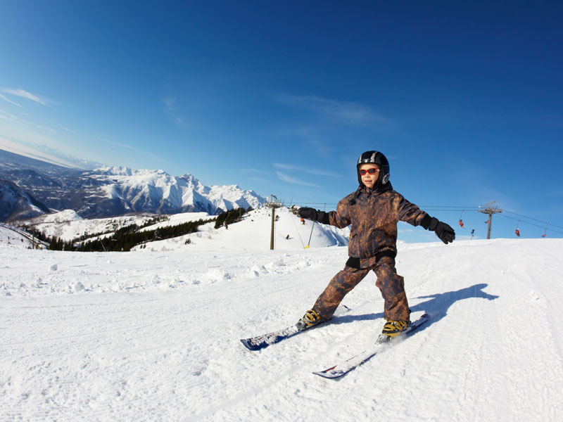 Enfant en colo de vacances qui apprends à skier