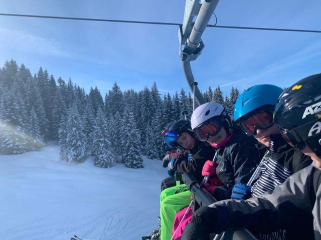 Jeune sur le télésiège qui sont en colonie de vacances à la neige