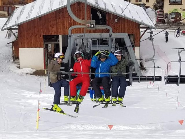 Groupe de jeunes de 8 à 15 ans en colo de vacances dans les Alpes qui profitent de leur séjour à la neige