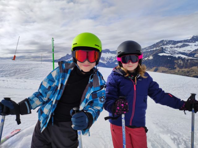 Deux jeunes skieurs en herbe en colo de vacances à la neige 